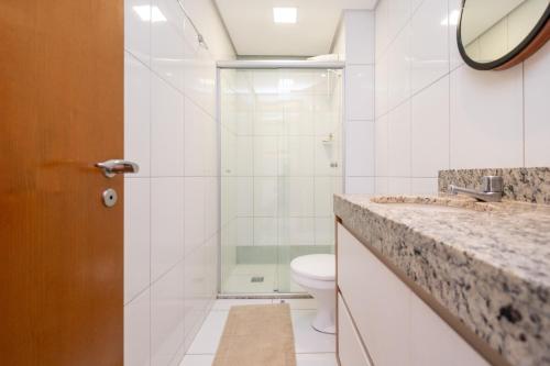 y baño con ducha, aseo y lavamanos. en Flat no melhor do Bueno, en Goiânia