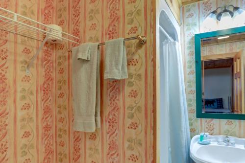 a bathroom with a sink and a mirror and a towel at Hot Tub and Game Room Powderhorn Mountain Cabin in Powderhorn Mountain