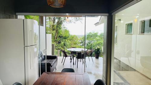 a dining room with a table and a sliding glass door at Suítes Costa Do Macacu-Garopaba in Garopaba