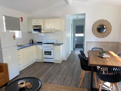 a kitchen with white appliances and a table and chairs at Ingenia Holidays Old Bar Beach in Old Bar