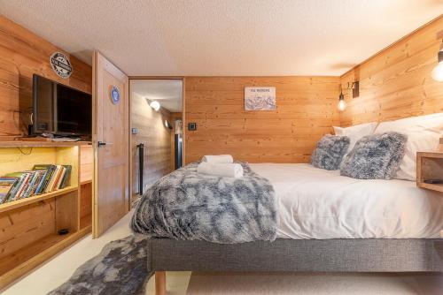 a bedroom with a bed with a blanket on it at Val Thorens - Cosy Duplex avec Vue Pied des pistes Silveralp 570 in Val Thorens