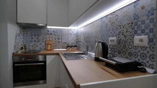 uma pequena cozinha com um lavatório e um fogão em Kristi Apartments 02 em Tirana