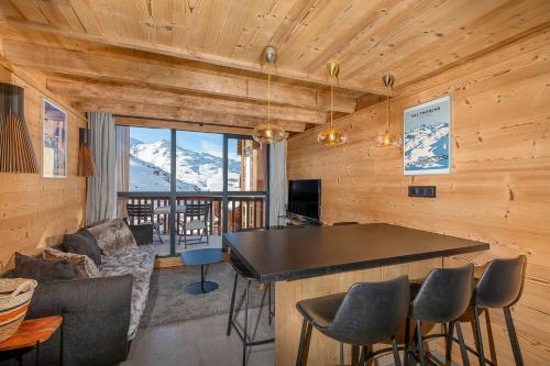 ein Wohnzimmer mit einer Bar mit Bergblick in der Unterkunft Val Thorens - Cosy Duplex avec Vue Pied des pistes Silveralp 570 in Val Thorens