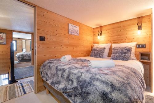 a bedroom with a large bed with wooden walls at Val Thorens - Cosy Duplex avec Vue Pied des pistes Silveralp 570 in Val Thorens