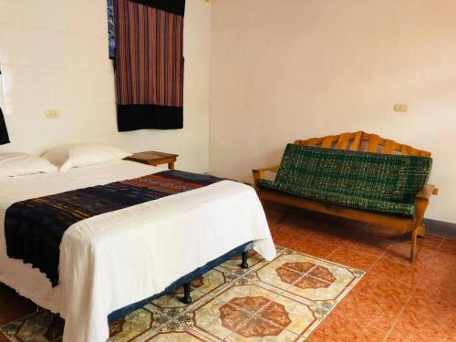a room with two beds and a bench in it at Mi casa es tu casa in San Pedro La Laguna