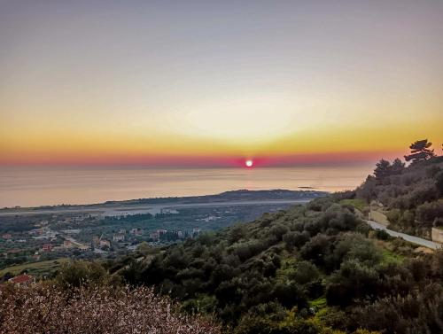 uma vista para o pôr-do-sol a partir do topo de uma colina em Irida's house em Cefalônia