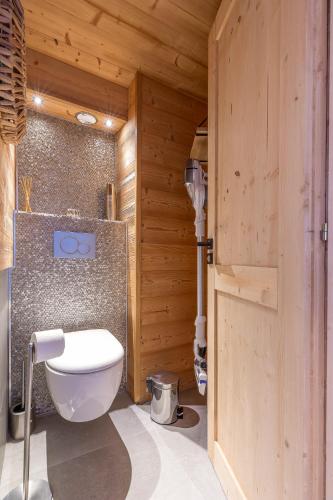 a bathroom with a toilet in a wooden room at Val Thorens - Cosy Duplex avec Vue Pied des pistes Silveralp 570 in Val Thorens