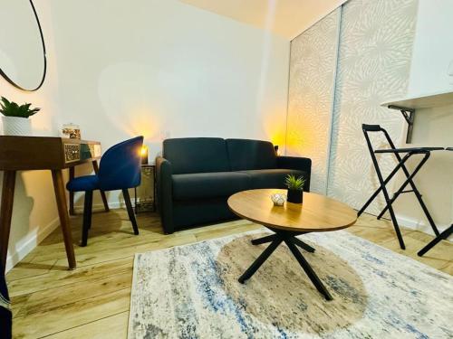 uma sala de estar com um sofá e uma mesa em Studio Cosy proche Paris - JO 2024 em Clichy