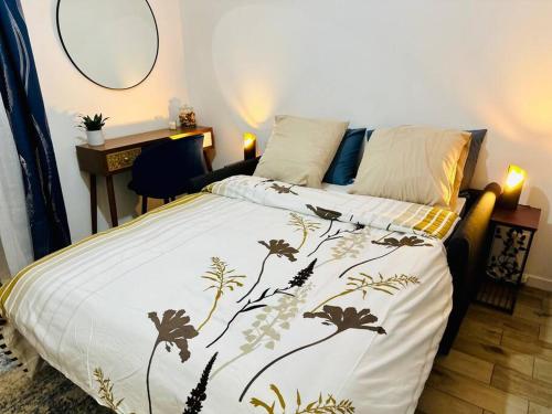 um quarto com uma cama com um edredão preto e branco em Studio Cosy proche Paris - JO 2024 em Clichy