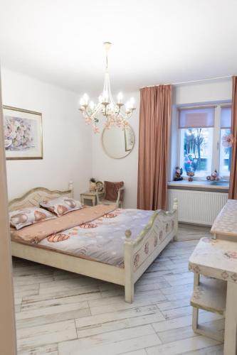 a bedroom with a bed and a chandelier at Vintage Apartament Ultracentral in Craiova