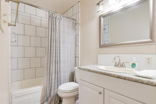 a bathroom with a toilet and a sink and a mirror at Fresno Apartment with Shared Grill and Dining Area in Fresno