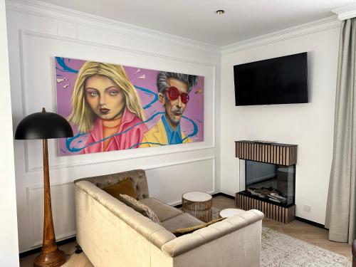a living room with a couch and a painting on the wall at Bubaqia House - Suites Boutique in Granada