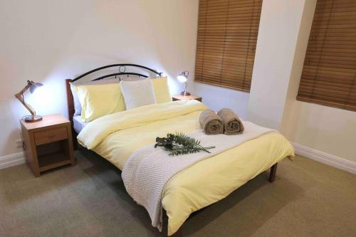 een slaapkamer met een groot bed met 2 hoeden en handdoeken bij Comfortable City Apartment *Wi-Fi* in Melbourne