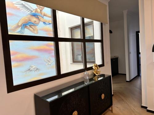 a room with three windows with angels on the wall at Bubaqia House - Suites Boutique in Granada