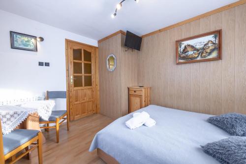 a bedroom with a bed and a table and chairs at U Majerczyka Dolina Apartment in Zakopane