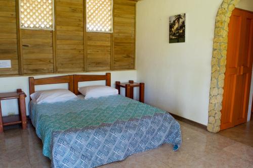una camera con un letto in una stanza con finestre di Hotel Rancherío Shangai a Moñitos