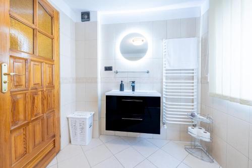 a bathroom with a sink and a wooden door at U Majerczyka Dolina Apartment in Zakopane