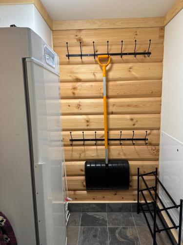 a room with a wood paneled wall with a black and yellow mop at Årebjørnen - Sadelen in Åre