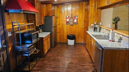uma cozinha com armários de madeira, um lavatório e um balcão em Holiday Haus em Mammoth Lakes