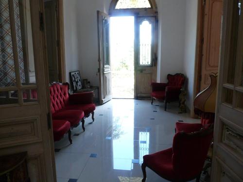 a hallway with red chairs and an open door at Chateau la Bouriette in Moussoulens