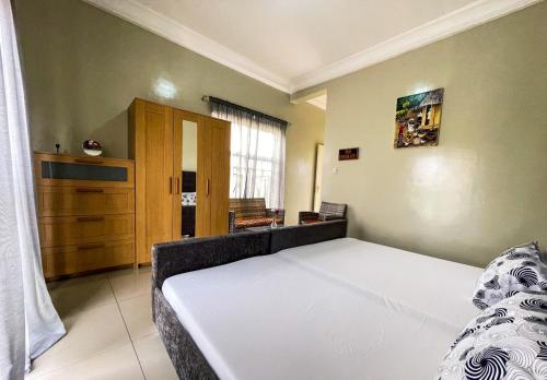 sypialnia z dużym białym łóżkiem w pokoju w obiekcie Lav's Place w mieście Brufut