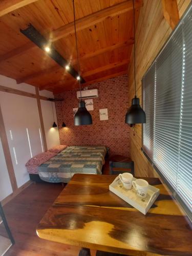a room with two beds and a wooden table at Los colibries in Mar de Cobo