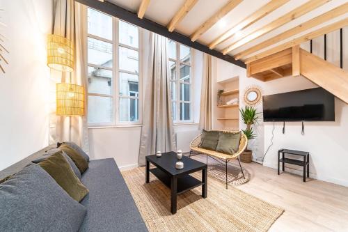 un salon avec un canapé et une télévision dans l'établissement Les Suites de l'Opéra - Apartment Ella for 4 people, à Lyon