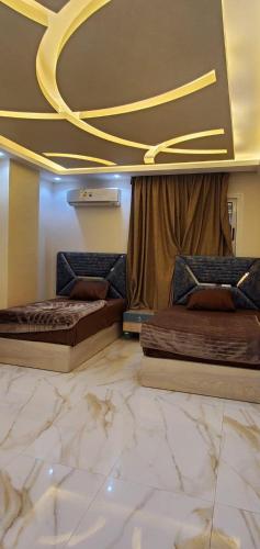 two beds in a room with a marble floor at شقق فندقيه مفروشه الترا مودرن للايجار in Cairo