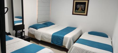 1 dormitorio con 2 camas con sábanas azules y blancas en Hotel Mykonos Manta en Manta