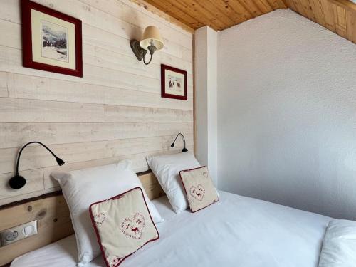 a bedroom with a white bed with two pillows at Le 101 Chalet 3 chambres Terrasse Parking in Cauterets