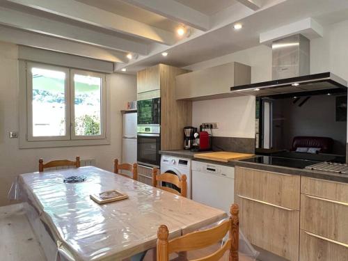 a kitchen with a table and a table and chairs at Le 101 Chalet 3 chambres Terrasse Parking in Cauterets