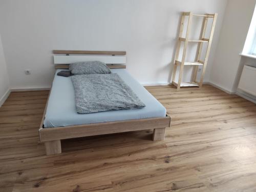 a bed in a room with a wooden floor at Furnished apartments for employees with separate rooms in Zeitz