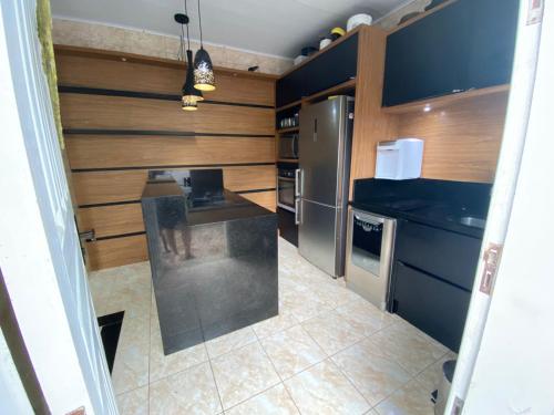 a kitchen with stainless steel appliances and wooden walls at Paraíso do santinho in Florianópolis