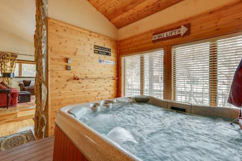 une baignoire jacuzzi dans une chambre avec des murs en bois dans l'établissement Granby Condo with Private Hot Tub Less Than 1 Mi to Ski Lift, à Granby