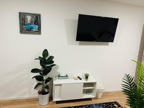 ein Wohnzimmer mit einem Fernseher an einer weißen Wand in der Unterkunft Ferienwohnung COCO Ochsenfurt in Ochsenfurt