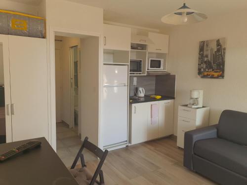 un salon avec un canapé et une cuisine dans l'établissement Quatro la corniche, à Sète