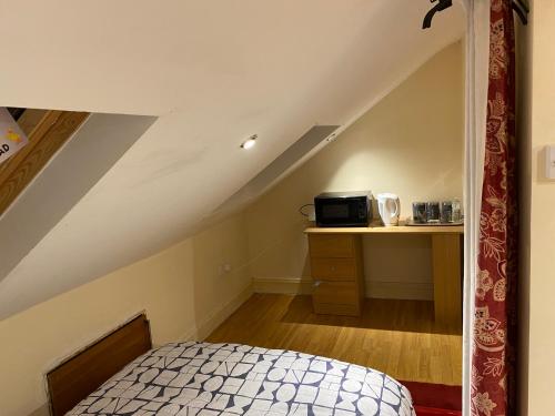 ein Schlafzimmer mit einem Bett und einem Schreibtisch im Dachgeschoss in der Unterkunft River Walk Canterbury in Kent