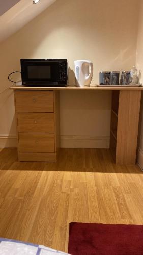 a wooden desk with a microwave on top of it at River Walk Canterbury in Kent