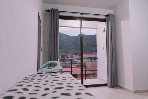 a bedroom with a bed and a window with a view at Aires de Altura y Singani in Tarija