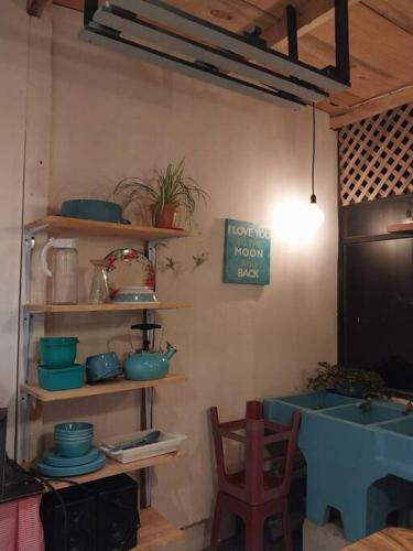 uma cozinha com prateleiras de madeira com pratos e uma mesa em Casa Xejulya em San Pedro La Laguna