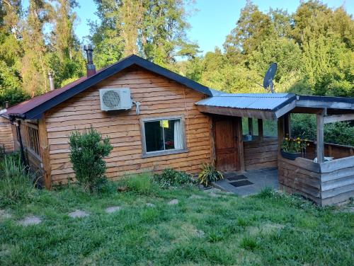a log cabin with a porch and a roof at Cabaña en parcela a 5 minutos de Valdivia in Valdivia
