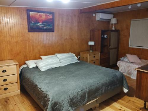 a bedroom with a bed and a tv in it at Casa de campo al lado de la ciudad 130 mts2 in Valdivia