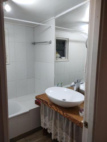 y baño con lavabo blanco y bañera. en Casa de campo al lado de la ciudad 130 mts2, en Valdivia