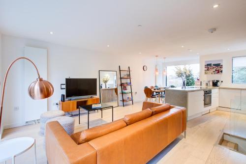 a living room with a couch and a kitchen at Neoteric Home Wimbledon Village in London
