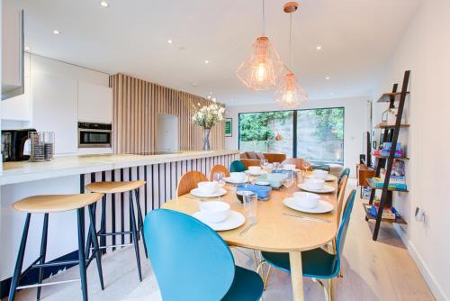 a kitchen and dining room with a table and chairs at Neoteric Home Wimbledon Village in London