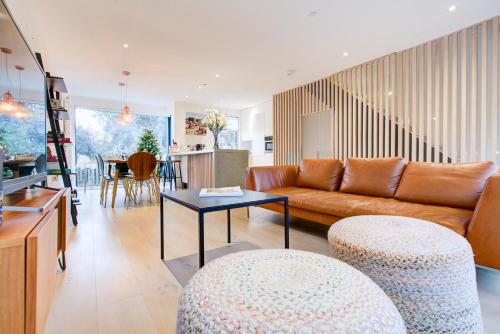 a living room with a couch and a table at Neoteric Home Wimbledon Village in London