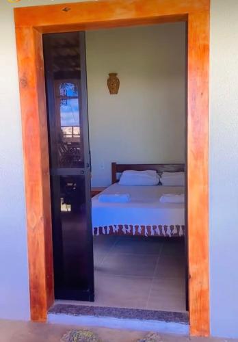 a door leading into a bedroom with a bed at Pousada das Canoas in Acaraú