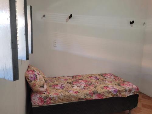 a bed in a room with a floral couch at Casa em Tibau RN. in Tibau