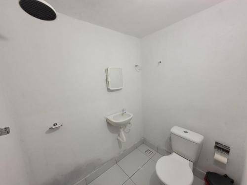 a white bathroom with a toilet and a sink at Casa em Tibau RN. in Tibau