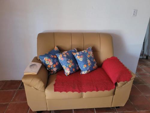 a brown couch with four pillows on it at Casa em Tibau RN. in Tibau